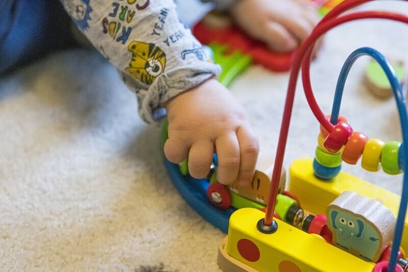 Rex playing with the Hape Rainbow Puzzle Wooden Train Set