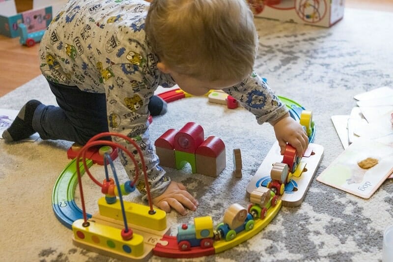 Rex playing with the Hape Rainbow Puzzle Wooden Train Set