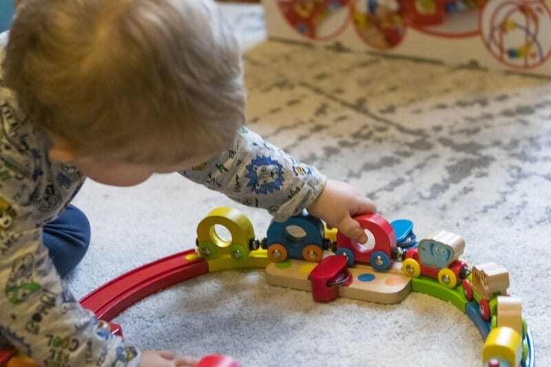 Rex playing with the Hape Rainbow Puzzle Wooden Train Set
