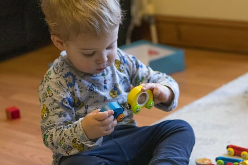 Rex playing with the Hape Rainbow Puzzle Wooden Train Set