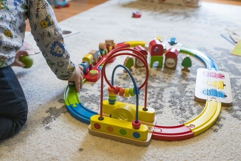 Rex playing with the Hape Rainbow Puzzle Wooden Train Set