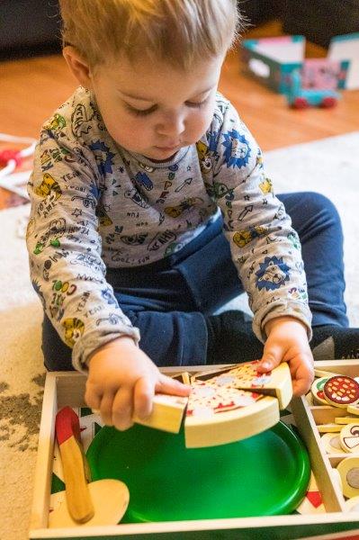 Rex playing with the Pizza Party Wooden Food set from Melissa and Doug