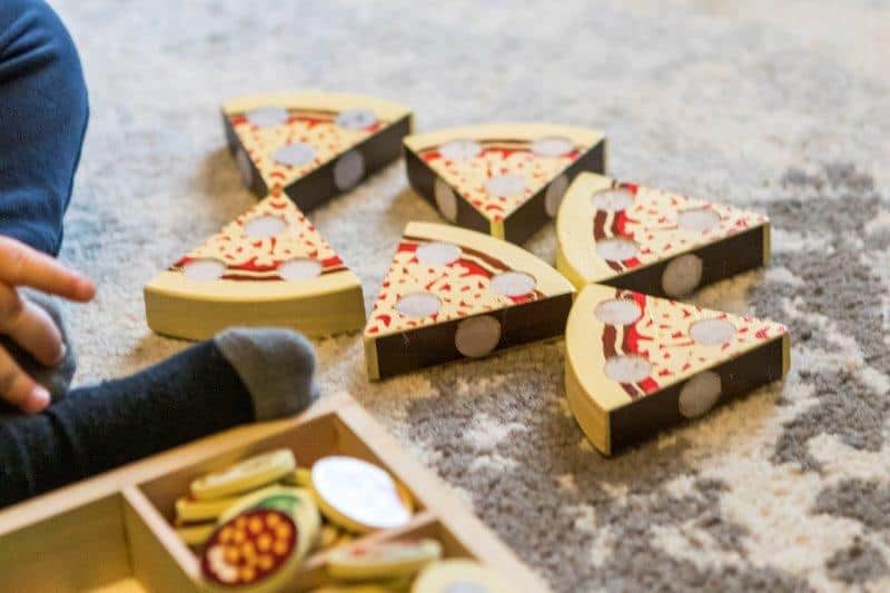 Rex playing with the Pizza Party Wooden Food set from Melissa and Doug
