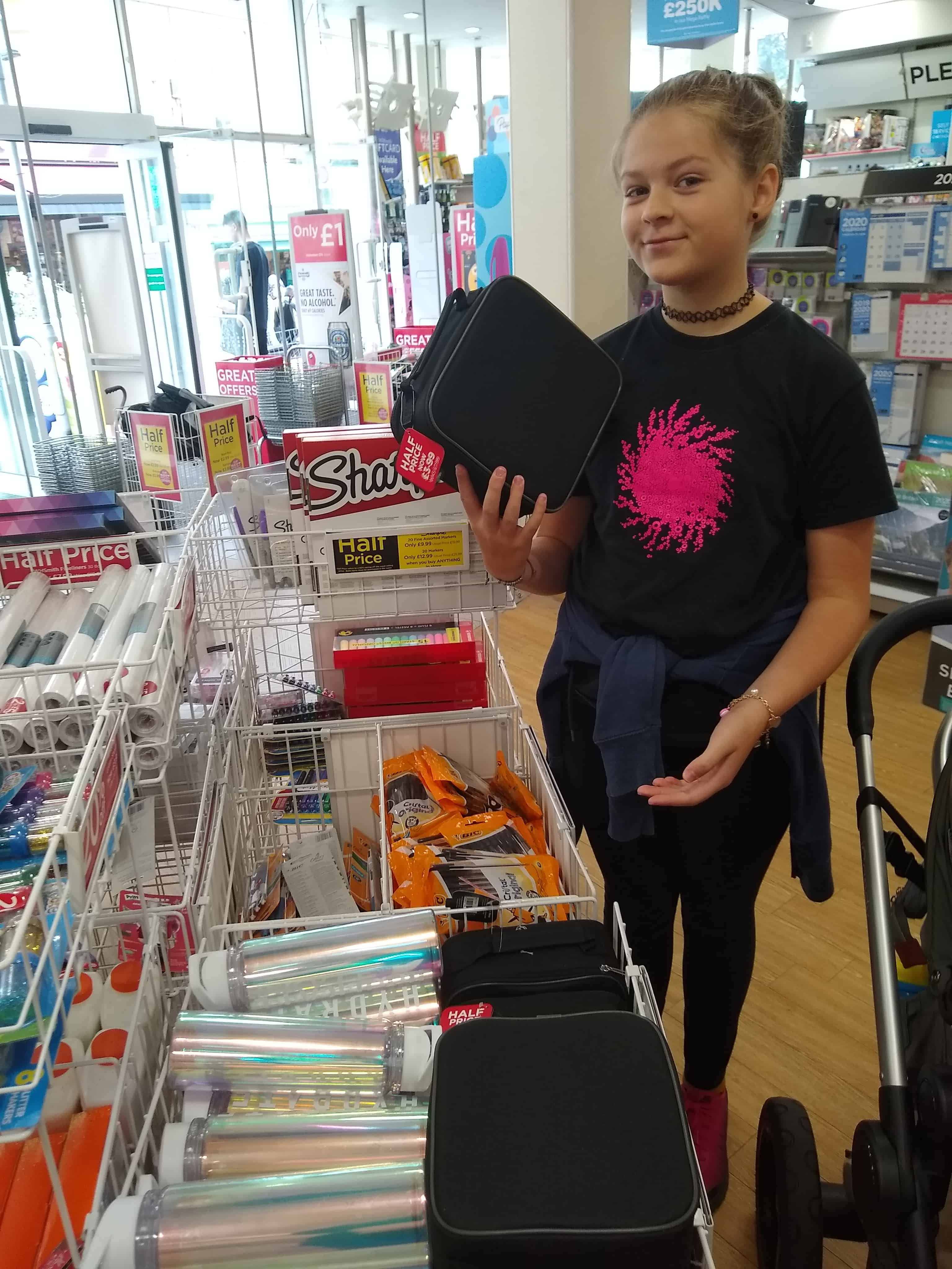 My daughter holding up a black canvas lunch bag in WH Smiths