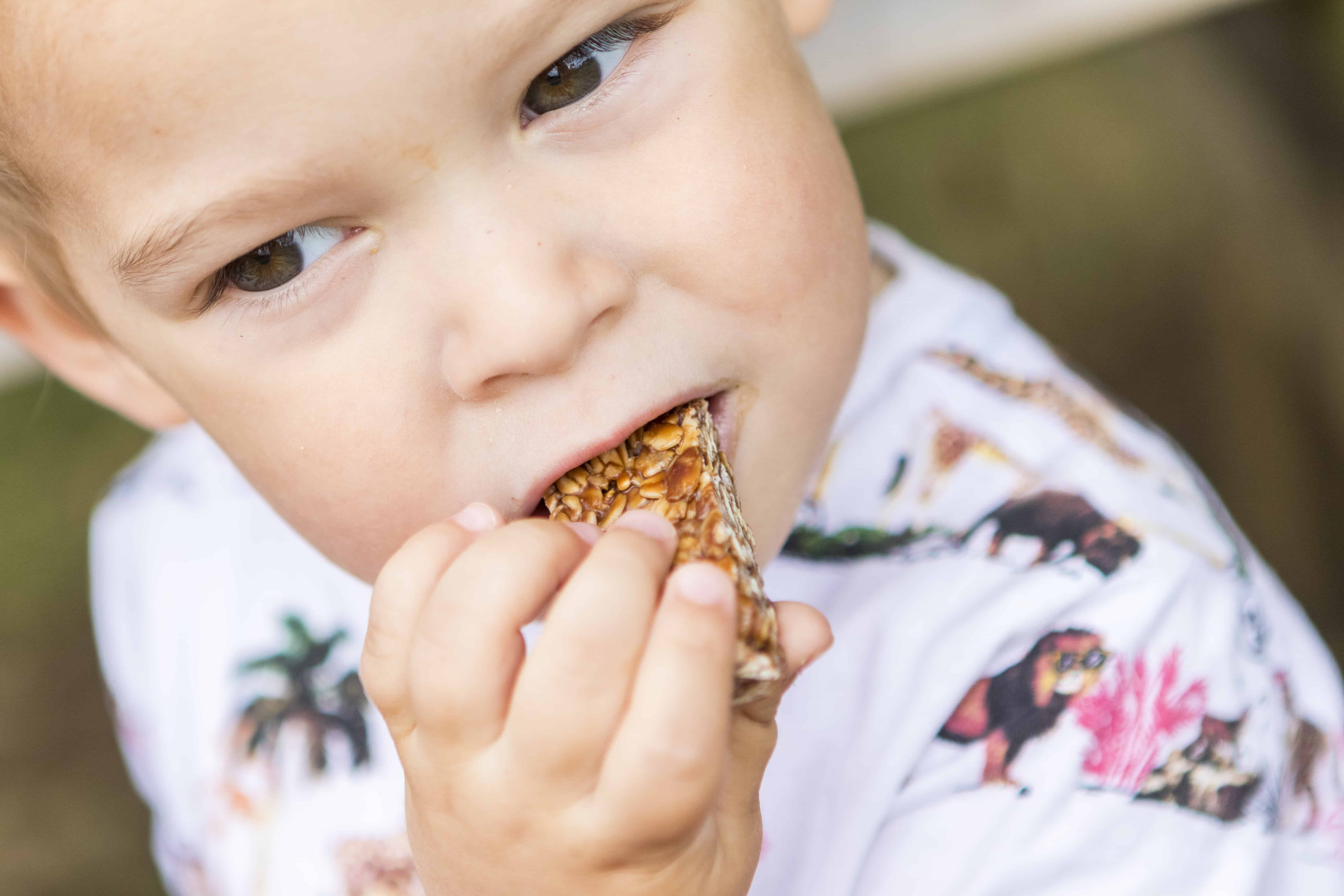 A close-up of a child eating a MadeGood bar