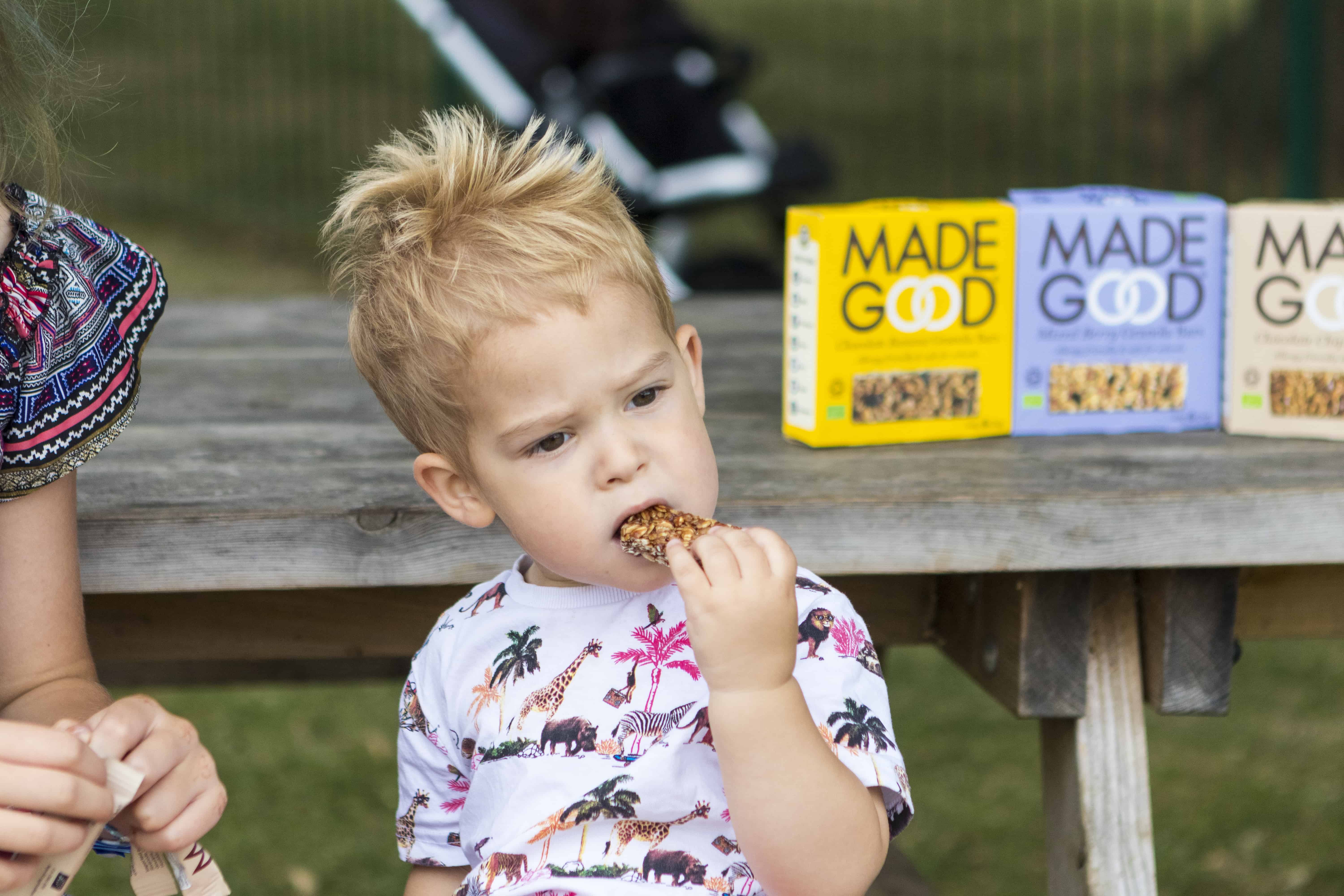 A small boy eating a MadeGood bar