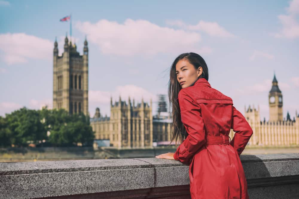 Woman in a red coast looking over a wall in London