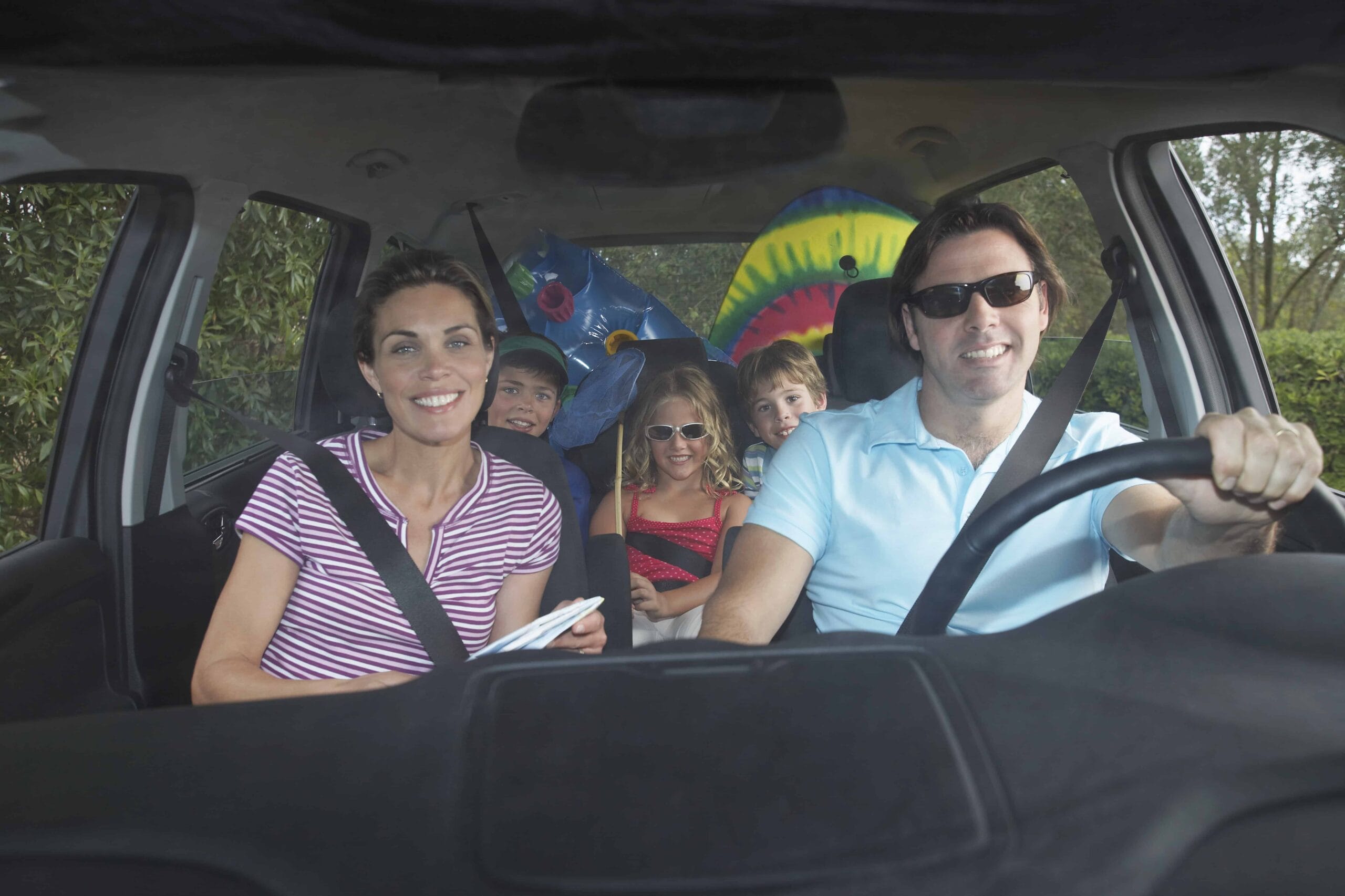 Family with three children (5-11) in car interior portrait