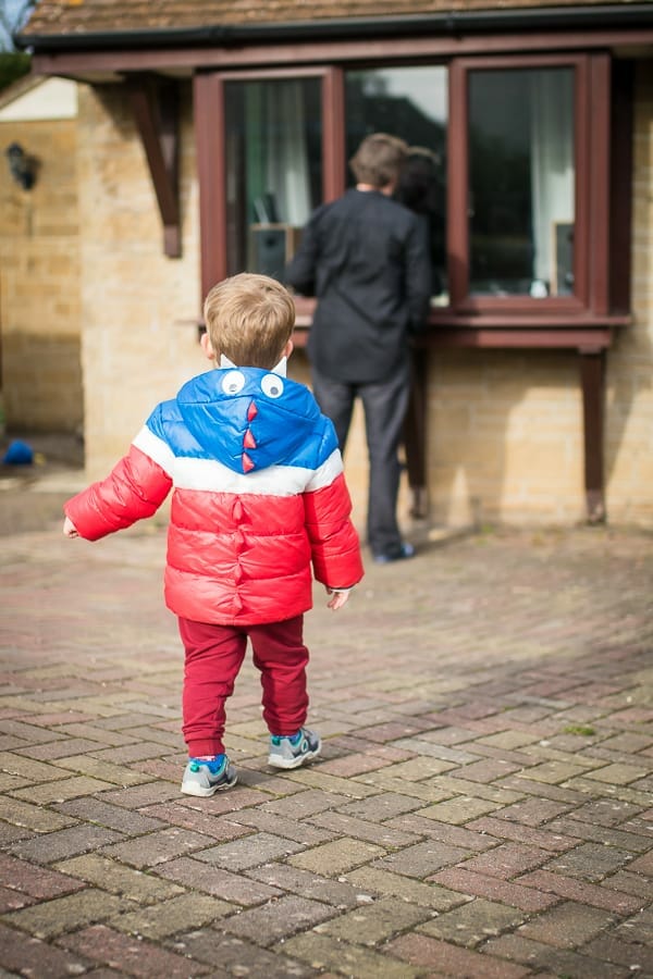 A little boy in a dinosaur coat playing Whats the Time Mr Wolf with his daddy